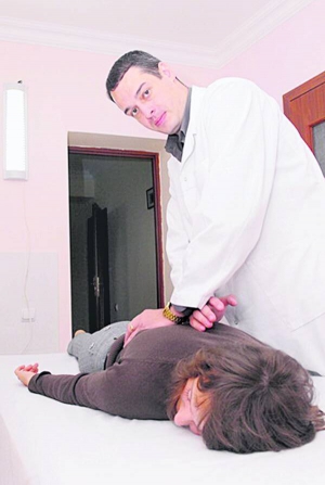 Директор медичного центру ”Меднеан” Андрій Нечай робить масаж пацієнтці центру. Жінка проходила курс лікування від остеохондрозу