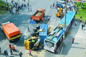 Перевернута вантажівка лежить біля тролейбуса на вулиці Вишгородській у Києві 28 квітня. Упала біля нього з 30 тоннами піску в кузові