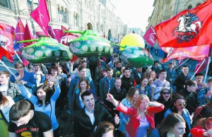 Демонстранти з прапорами і повітряними кульками йдуть Красною площею у Москві під час ходи 1 травня