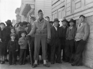 "Натовп роззяв в перший день евакуації з японського кварталу в Сан-Франциско, які самі будуть евакуйовані протягом трьох днів." Сан-Франциско, Каліфорнія, квітень 1942 року