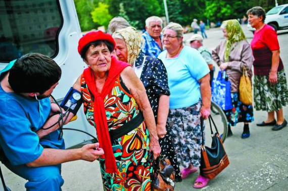 Люди біля мерії Слов’янська 9 липня чекають на гуманітарну медичну допомогу. Ліки та продукти в місто завозять щодня. Відновили роботу лікарні та дві хлібопекарні