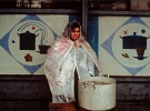 Женщина под дождем подает суп на рынке