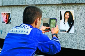 Під час поминальної церемонії на площі Свободи в Харкові 24 липня малайзій­ський експерт фотографує портрет жінки, яка загинула в авіакатастрофі. Над Донеччиною лайнер збили терористи
