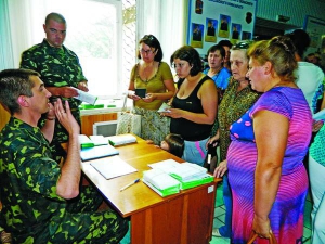 Начальник фінансового відділу Вінницького обласного військкомату Андрій Химич просить матерів та дружин військових стати в чергу. Жінки хочуть отримати дублікати банківських карток, на які нараховують зарплату за службу в зоні АТО