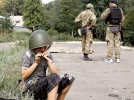 Хлопчик із райцентру Попасна на Луганщині вдягає шолом, який йому дали бійці добровольчого батальйону ”Донбас”, 4 серпня 2014 року. Батальйон звільнив це місто від проросійських терористів 22 липня