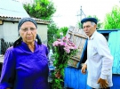 Батьки Сашка Білого Олена та Іван Музичко біля криниці на своєму подвір’ї в селі Бармаки під Рівним. Жінка нарізала квітів, щоб віднести до місця, де міліціонери застрелили сина