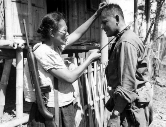 Филиппинская партизанка Нивес Фернандес показывает американскому солдату, как она убивала японских солдат во время оккупации. 1944 год