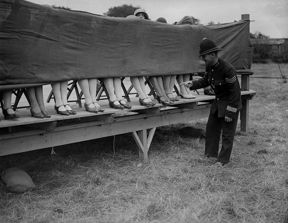  Поліцейський оцінює щиколотки учасниць конкурсу краси в Лондоні. 1930
