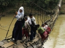 В одному індонезійському селищі діти, що живуть по той бік річки Сіберанг, повинні пройти по зламаному підвісному мосту.