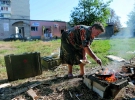 Жінка готує їжу на вогнищі у дворі свого будинку, Іловайськ Донецької області, 31 серпня 2014 року