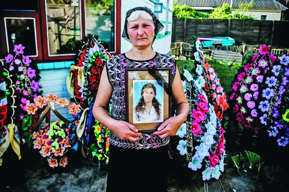 Валентина Нечай тримає фотографію загиблої доньки Оксани. Та сама виховувала двох синів, п’яти і двох років