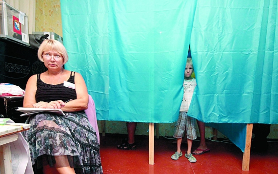 14 вересня хлопчик визирає з кабінки для голосування на виборчій дільниці в Севастополі