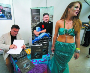 Раїса Реус у костюмі русалки пропонує відвідувачам Форуму видавців придбати книжки Миколи Хомича