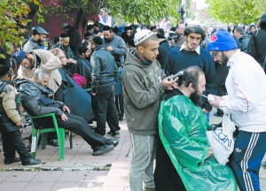 Хасидам під дощем роблять зачіски в місті Умань на Черкащині 24 вересня. Вони святкували там 5775-й юдейський Новий рік — Рош а-Шана