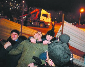 Міліціонери відтягують чоловіка, який намагався знести паркан довкола будівельного майданчика навпроти метро Осокорки 17 листопада