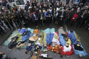 На столичному майдані Незалежності моляться над тілами розстріляних протестувальників.  20 лютого 2014 року