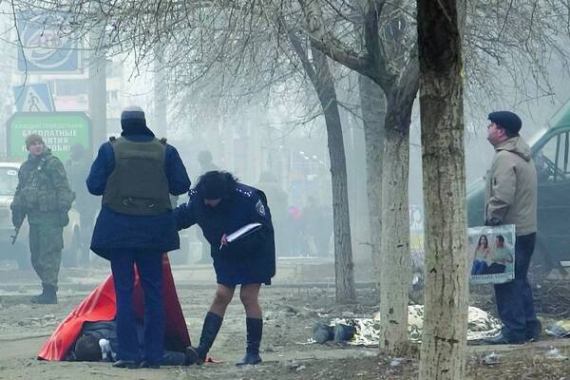 Міліція оглядає тіло загиблого в житловому масиві Маріуполя. Місто бойовики обстріляли в суботу 24 січня