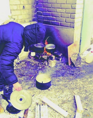 Жителька міста Дебальцеве на Донеччині готує їжу надворі. Через постійні обстріли в будинках немає світла, води й опалення
