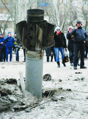 Жителі Краматорська на Донеччині фотографують частину ракети, що застряла в землі. 10 лютого терористи обстріляли місто зі ”Смерчів”. Загинули 17 людей