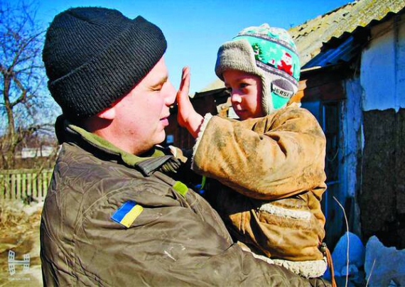 У селі Донецької області солдат із 79-ї бригади грається з місцевим хлопчиком. Він називає бійця своїм роботом. Щоранку прибігає, щоб ввімкнути — натиснути на ніс