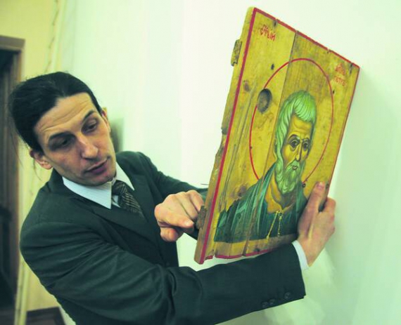 Художник Олександр Клименко показує ікону, що намалював на шматку ящика з-під снарядів. Їх привезли волонтери із зони АТО