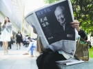 Чоловік тримає газету із новиною про смерть Лі Куан Ю на вулиці Сингапуру
