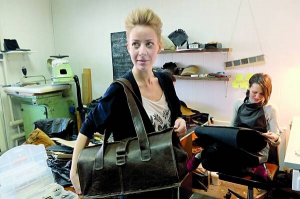 Співзасновниця столичної майстерні ”Ремейд” Ганна Сігорська показує сумку,  пошиту із вживаного одягу. Закуповують його на секонд-хендах та в інтернеті