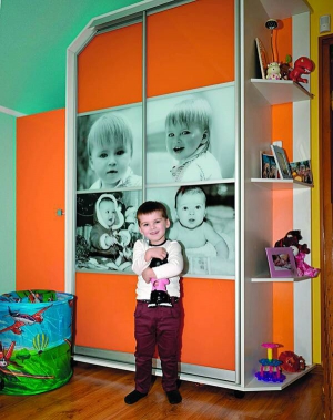 Кирило Турчик біля шафи з власними фото. Коли хлопчик підросте, батьки доклеять ще два знімки