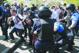Правоохоронці тримають чоловіків, які намагаються прорватися на мітинг комуністів 1 травня. 19 з них затримують