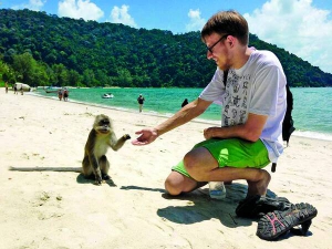 Мандрівник Богдан Логвиненко бавиться із мавпочкою на острові Пенанг, Малайзія, влітку позаторік