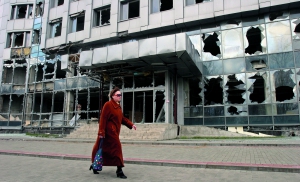 Жінка йде через розбомблену будівлю в Донецьку