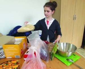 Школярка Еліза Рудько збирає сухий борщовий набір для українських бійців. Щотижня з батьками готує сотню пакунків