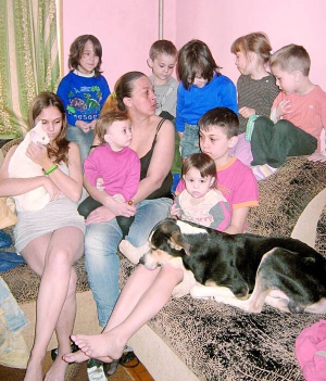 Віра Буцер сидить із дітьми на дивані у своїй кімнаті. Шість років перебуває в декреті. Щомісяця отримує 10 тисяч гривень соцдопомоги