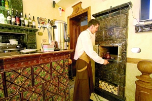 Офіціант львівського кафе ”Теплий п’єц” подає каву в глиняній турці