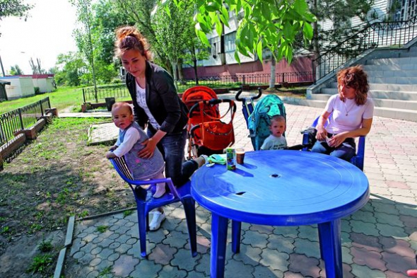 22-річна Анна і 24-річна Айгюна бавлять немовлят біля кафе ”Кактус” у центрі Степногірська. Їхні чоловіки на заробітках у Запоріжжі і в Росії