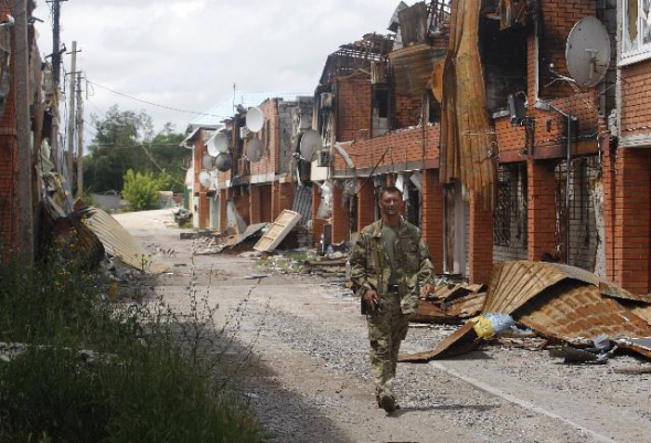 Український солдат проходить зруйнованою вулицею села Широкине Донецької області в червні 2015 року.