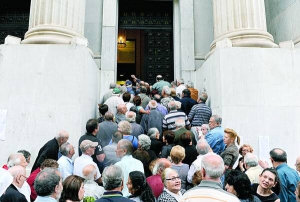 Люди чекають на виплату частини пенсії біля відділення Національного банку Греції в Салоніках, 1 липня