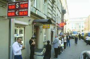 Люди стоять в черзі перед пунктом обміну валюти у центрі Москви в понеділок, 24 серпня. Більшість пунктів вивісили оголошення, що валюти в продажу немає. Деякі продавали не більше 200 доларів США в одні руки