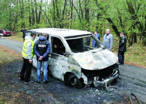 Експерти оглядають згорілий автомобіль, у якому загинули троє інкасаторів поблизу села Скорінець Чернігівського району