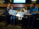 Арина и Лев демонстрируют сертификаты рекордов с родителями
