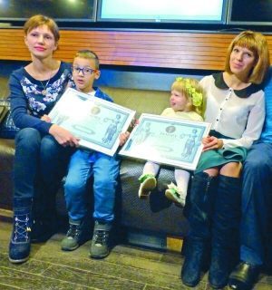 2-річна Аріна Шугалевич і Лев Бондаренко, 6 років, показують свої сертифікати Національного реєстру рекордів України за найкраще знання столиць світу