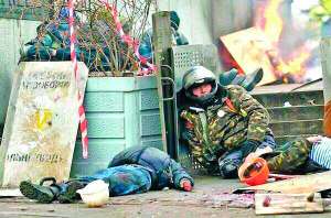 Майданівець сидить на тротуарі на вулиці Інститутській. Поряд — тіла загиблих побратимів. 20 лютого 2014 року