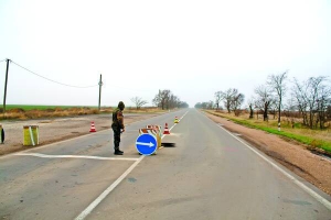 Боєць батальйону ”Азов” дивиться в бік Криму. На блокпосту перевіряють автомобілі, які виїжджають із півострова