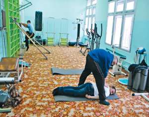 Інструктор з лікувальної фізкультури робить масаж бійцю АТО на індивідуальному занятті