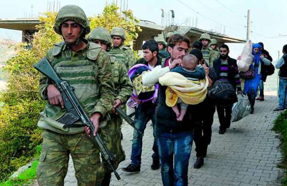 Турецькі солдати супроводжують сім’ї сирійських біженців. Вони незаконно перетнули кордон із Туреччиною у її південній провінції Хатай. 27 листопада 2015 року