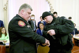 Спецпризначенець надягає наручники Сергію Бочковському. За тиждень його звільнять під заставу