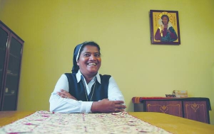Сестра Ліджі сидить за столом у монастирі сестер ордену Святого Йосифа де Сен-Марк у Києві. Її родина живе в Індії. Має п’ятьох братів і трьох сестер. За освітою — вчителька англійської мови