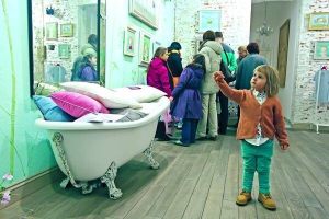 Дівчинка прийшла на виставку художниці Євгенії Гапчинської до столичної галереї ”Щастя”. Показали зо три десятки картин