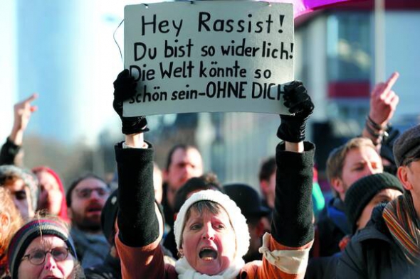 Противники антиімміграційного руху ”Патріотичні європейці проти ісламізації Заходу” протестують перед мітингом PEGIDA в Кельні, Німеччина, 9 січня 2016 року.  На плакаті написано: ”Расисти, ви надто огидні! Світ може жити без вас”