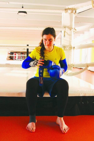 Киянка Тетяна Шевченко сидить на рингу. Боксом займається два роки. Через щоденні тренування розійшлася з хлопцем